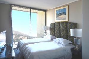 a bedroom with two beds and a large window at 214 Harbour Bridge in Cape Town