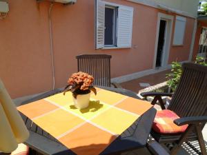 a table with a vase of flowers on a patio at Apartments Helena in Orebić