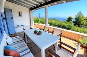 a table and chairs on a patio with a view of the ocean at Domus Nostos in Apolpaina