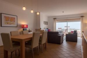 uma sala de jantar e sala de estar com mesa e cadeiras em Maravilhoso T2 Vila da Praia em Amoreira