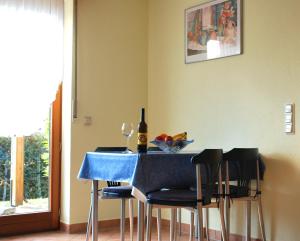 una mesa azul con sillas y una botella de vino en Christina, en Tünsdorf