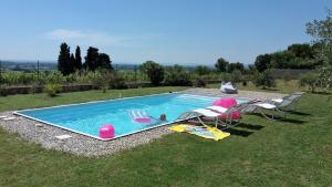 a swimming pool with two chairs and a table at La bastide de Lily in Séguret