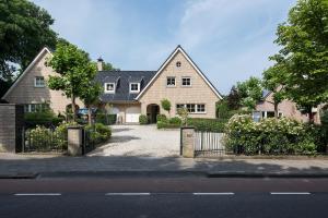 a large house with a gate and a driveway at Parc House Zandvoort in Zandvoort