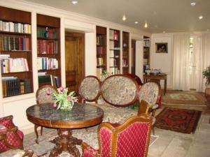 - un salon avec des chaises, une table et des étagères dans l'établissement Domaine de la Dame de Laurière, à Solignac