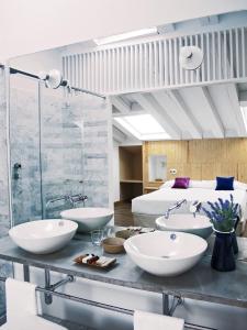 a bathroom with three sinks and a bed at Hotel Ayllon in Ayllón