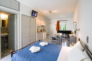 a bedroom with a blue bed and a kitchen at Balito in Kato Galatas