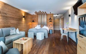 a hotel room with a bed and a couch at Wellnesshotel Erica in Nova Ponente