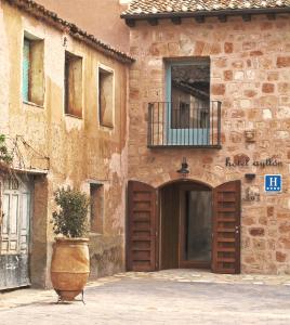 un bâtiment avec une porte et une usine devant lui dans l'établissement Hotel Ayllon, à Ayllón