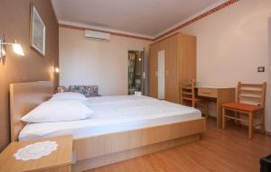 a bedroom with a large bed and a desk and a table at Villa Daniela in Brodarica