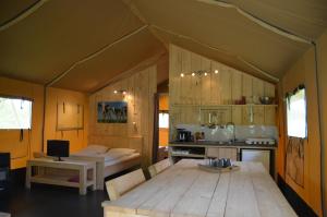 a room with a bed and a kitchen in a tent at Siblu De Lente van Drenthe in Gasselte