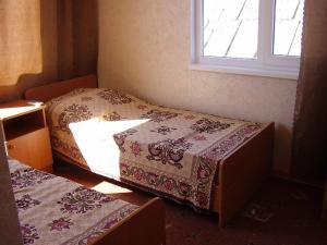 two beds in a room with a window at Роза in Lazarevskoye