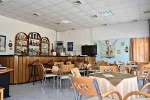 ケラモティにあるKaragiannisのテーブルと椅子のあるレストラン、バー