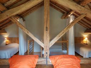 a room with two beds in a room with wooden ceilings at Gite la Fargue de Cabre in Vicdessos