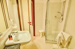 a bathroom with a shower, sink, and tub at Bajamar Beach Hotel in Formia