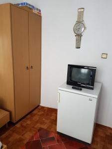 a room with a television and a clock on the wall at Guest Rooms Denitsa in Obzor