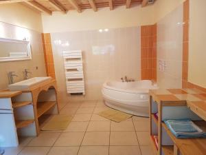 un bagno con vasca, WC e lavandino di Gite la Fargue de Cabre a Vicdessos