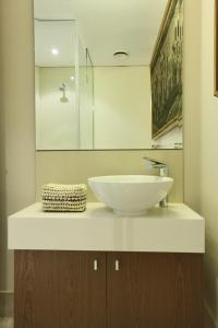 a bathroom with a white sink and a mirror at 702 Canal Quays in Cape Town