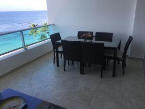 a dining room with a table and chairs and the ocean at Marbella Juan Dolio in Juan Dolio