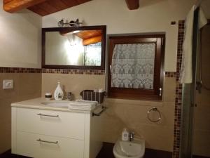 a bathroom with a sink and a toilet and a window at Il Giardino degli Ulivi in Castellana Grotte