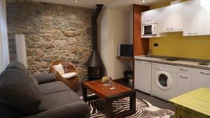 SalienciaにあるApartamentos Lagos de Salienciaのソファとテーブルとキッチンのあるリビングルーム