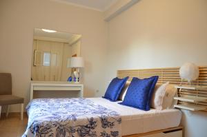 a bedroom with a large bed with blue pillows at Casa Afrodite in Corfu