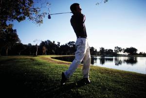 Un uomo che dondola una mazza da golf in un lago di 702 Canal Quays a Città del Capo