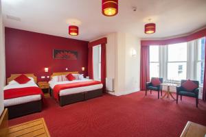 a hotel room with two beds and red walls at Adelphi Portrush in Portrush