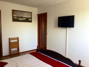 a bedroom with a bed and a flat screen tv at Casa Bella Turda in Turda