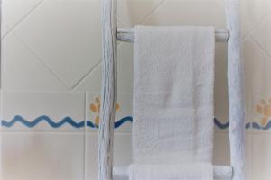a white towel hanging on a white towel rack at By the C house in Vila Nova de Milfontes