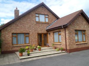 a brick house with potted plants on the steps at Rosslare Strand Rooms Only Accommodation in Rosslare