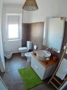 シラクーサにあるla Casetta in Altoのバスルーム(洗面台、トイレ、鏡付)