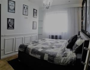 a bedroom with a bed with a quilt on it at Casa Mia - Modern Luxury Apartament in Bucharest +5 photos