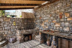 a stone building with a fireplace and a wooden table at Sea and Mountain View in Kalamata