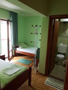 a bedroom with a bed and a bathroom with a toilet at Guest House Pansion 10 in Cetinje