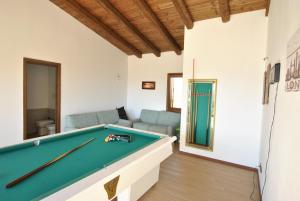 sala de estar con mesa de billar y sofá en Villa Bouganvillae, en Cugnana