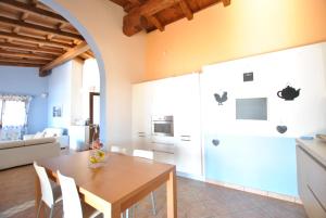 cocina y comedor con mesa de madera y sillas en Villa Bouganvillae, en Cugnana