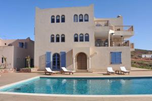 a house with a swimming pool in front of a house at Auberge Dar Najmat in Mirleft