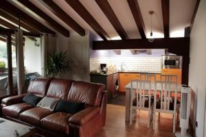 uma sala de estar com um sofá de couro e uma mesa em Eguzkitze Alojamiento Rural LSS00085 em Abaltzisketa