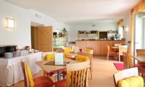 - une salle à manger et une cuisine avec une table et des chaises dans l'établissement Hotel Filipinum, à Merano