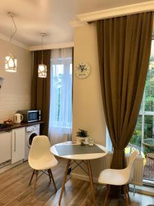 スヴェトロゴルスクにあるLakeCity Apartmentsのリビングルーム(テーブル、椅子、窓付)