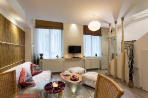 ein Wohnzimmer mit einem Tisch und einem Sofa in der Unterkunft Suites 13 Budapest in Budapest