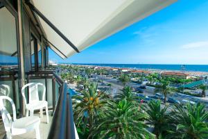 a balcony with chairs and a view of a city at Hotel Caesar Residence & SPA in Lido di Camaiore