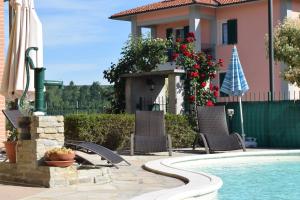 a house with a swimming pool and chairs and a house at Bene&Breakfast in Bene Vagienna