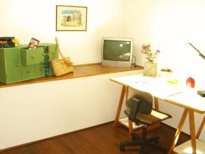an office with a desk and a tv on a counter at Residenza Alice 2 - Toscana mare e monti in Camaiore