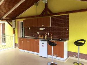 a kitchen with a sink and a counter with two stools at Casa Bella Turda in Turda