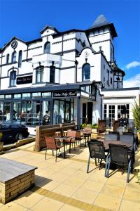 a restaurant with tables and chairs in front of a building at Dukes Folly Hotel in Southport