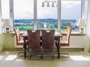 einen Esstisch mit Stühlen vor dem Fenster in der Unterkunft Ferienwohnung im Wikingturm mit Blick auf die Schlei - Willkommen in Schleswig! in Schleswig