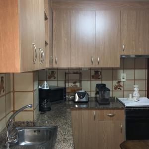 a kitchen with wooden cabinets and a sink at Playa Silgar en Galicia in Sanxenxo