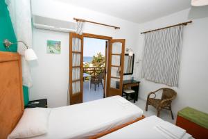 1 dormitorio con cama, escritorio y ventana en Azolimnos Bay, en Azolimnos