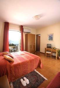 a bedroom with a bed and a desk and a window at Hotel Natalina in Taormina